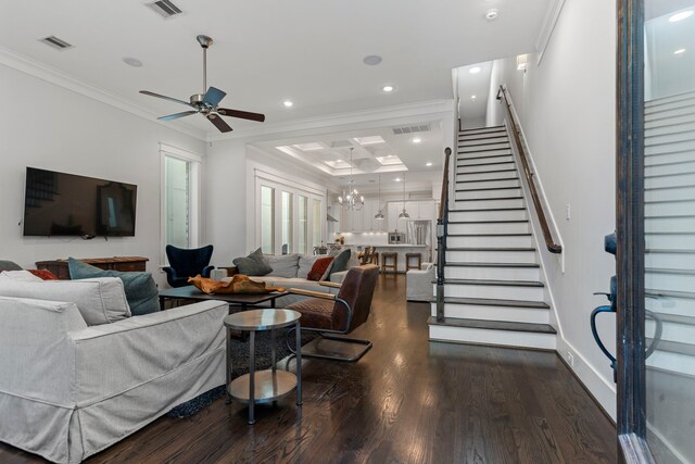 living room with ceiling fan with notable chandelier, dark hardwood / wood-style flooring, and ornamental molding