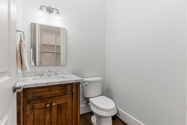 bathroom featuring vanity, hardwood / wood-style flooring, and toilet