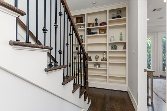 stairway with wood-type flooring and ornamental molding