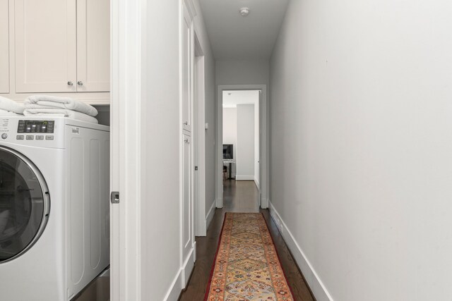 clothes washing area with washer / clothes dryer, dark hardwood / wood-style flooring, and cabinets