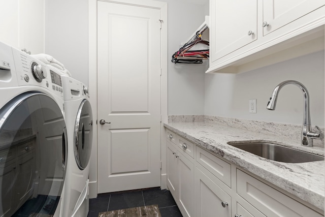 washroom with cabinets, separate washer and dryer, dark tile patterned flooring, and sink