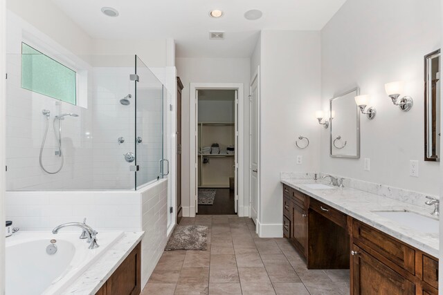 bathroom with tile patterned floors, vanity, and shower with separate bathtub