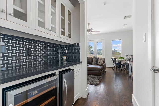 bar featuring stainless steel refrigerator, sink, wine cooler, dark hardwood / wood-style floors, and white cabinets