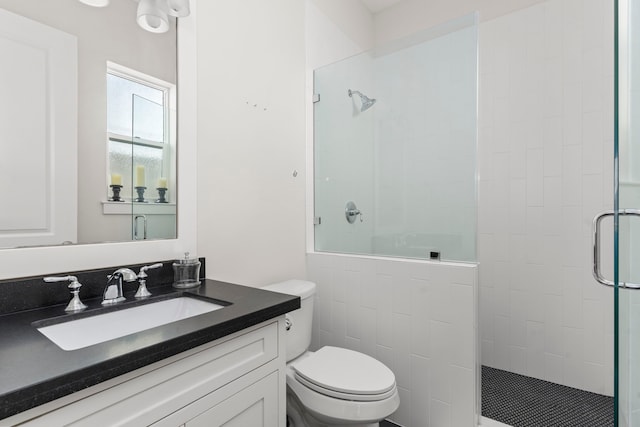 bathroom with an enclosed shower, vanity, and toilet