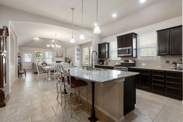 kitchen with tasteful backsplash, a large island, stainless steel appliances, lofted ceiling, and pendant lighting