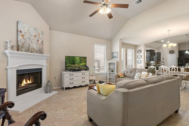 living room featuring light tile patterned floors, lofted ceiling, and ceiling fan with notable chandelier