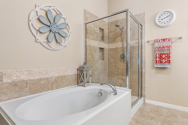 bathroom with independent shower and bath and tile patterned floors