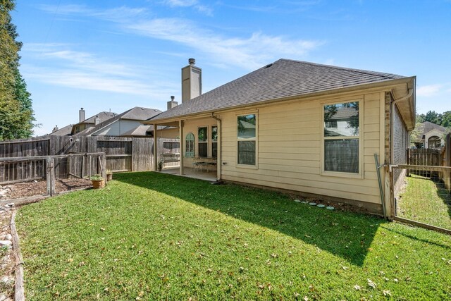 back of property featuring a yard and a patio area