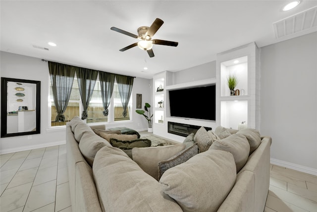 tiled living room featuring ceiling fan and built in shelves