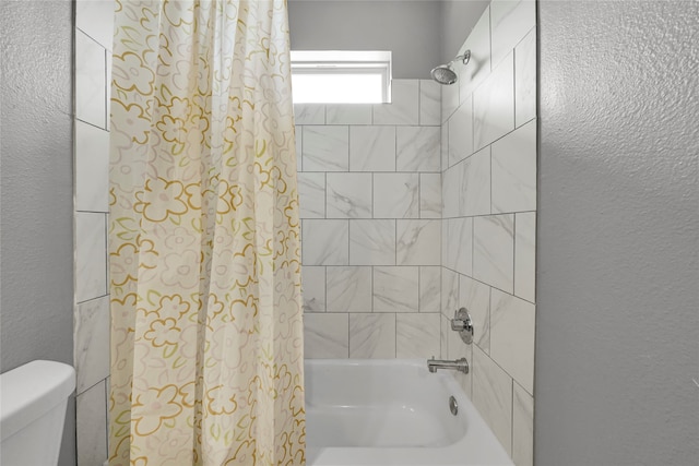 bathroom featuring shower / bath combo and toilet