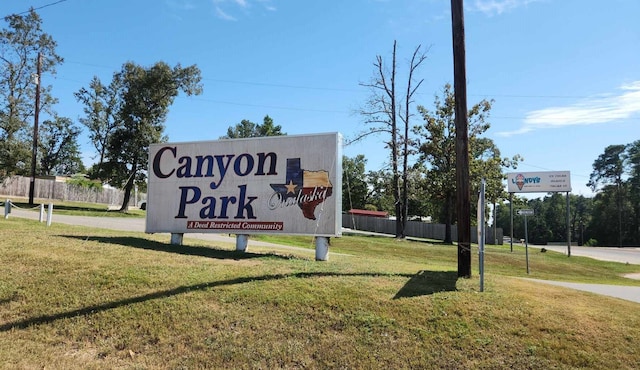 community / neighborhood sign featuring a lawn