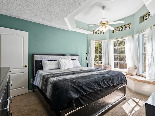 bedroom with ceiling fan, carpet floors, and a textured ceiling