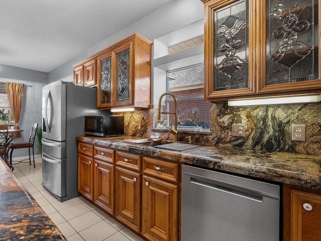 kitchen with decorative backsplash, appliances with stainless steel finishes, light tile patterned floors, and sink