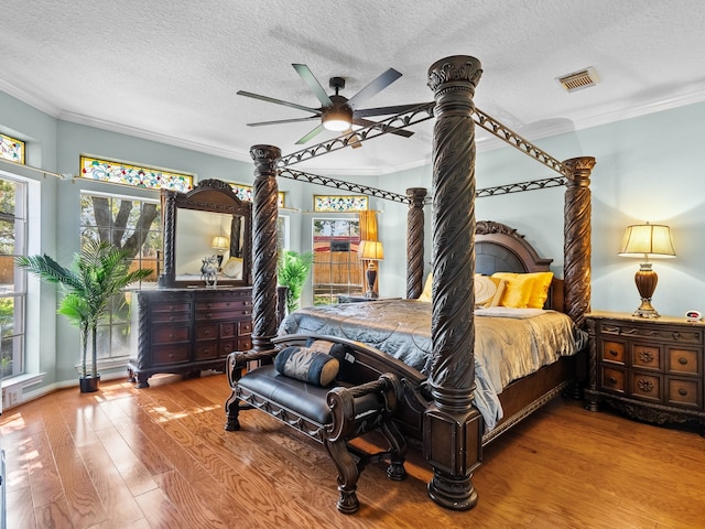 bedroom with ceiling fan, crown molding, and wood-type flooring