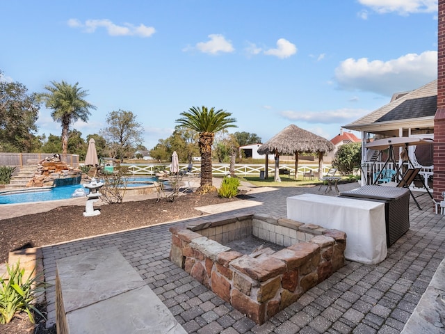 view of patio / terrace with a gazebo, pool water feature, a fenced in pool, and a fire pit