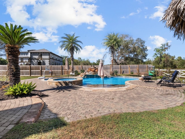 view of pool featuring a patio area and an in ground hot tub