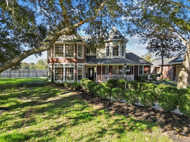 back of house featuring a yard and covered porch