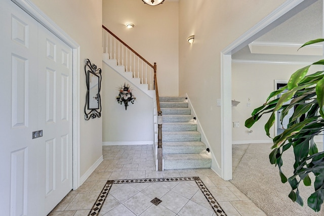 entrance foyer featuring ornamental molding and light colored carpet