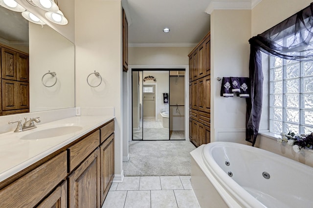 bathroom with tile patterned flooring, a relaxing tiled tub, vanity, and a healthy amount of sunlight