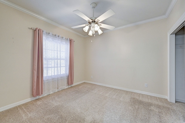 spare room with ceiling fan, light colored carpet, and crown molding