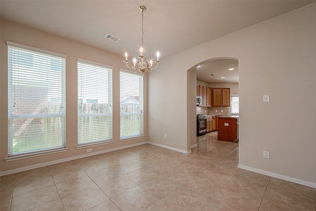 unfurnished dining area with light tile patterned floors and an inviting chandelier