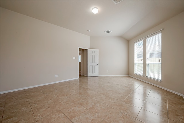 unfurnished room featuring light tile patterned floors and vaulted ceiling