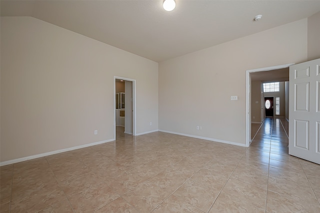 tiled spare room with lofted ceiling