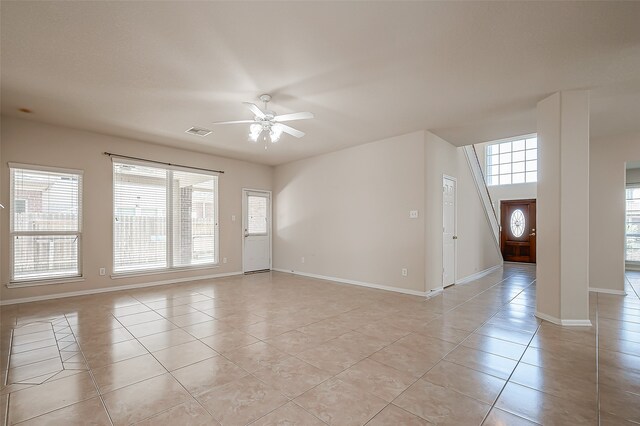 tiled spare room featuring a wealth of natural light and ceiling fan