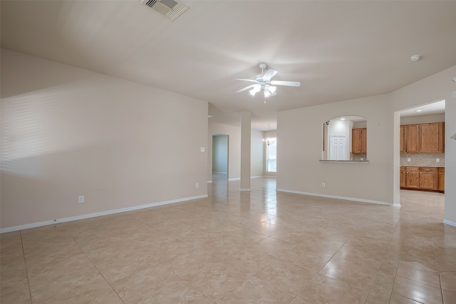 spare room featuring light tile patterned floors and ceiling fan with notable chandelier