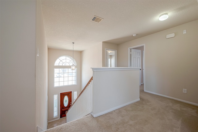 carpeted entryway with a textured ceiling