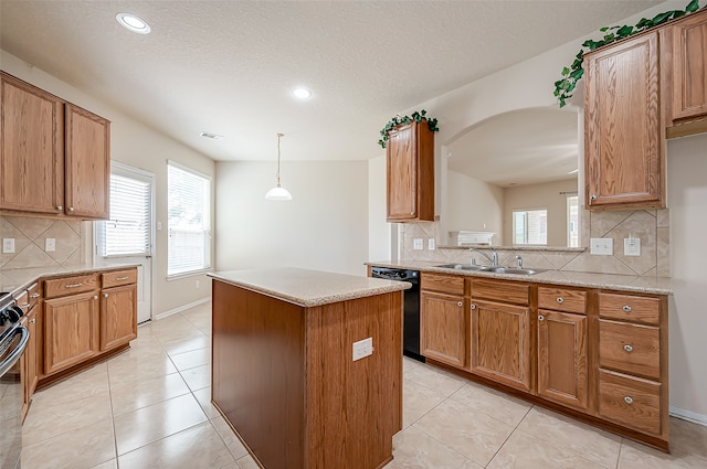 kitchen featuring black dishwasher, a kitchen island, a wealth of natural light, and sink