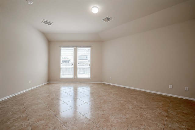 tiled empty room with vaulted ceiling