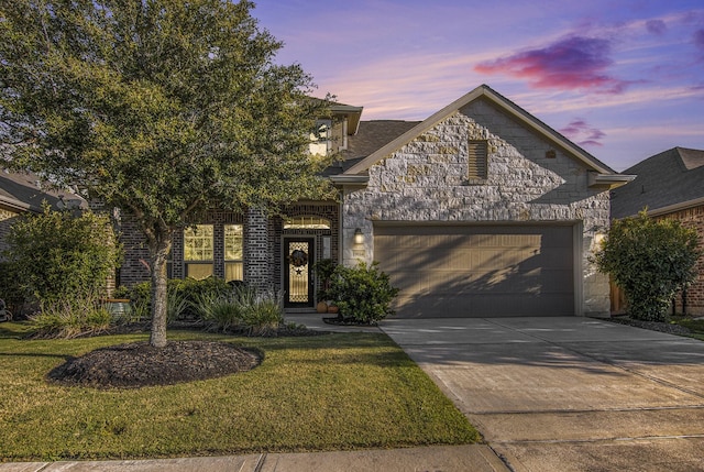 view of front of home with a front yard, stone siding, an attached garage, and concrete driveway