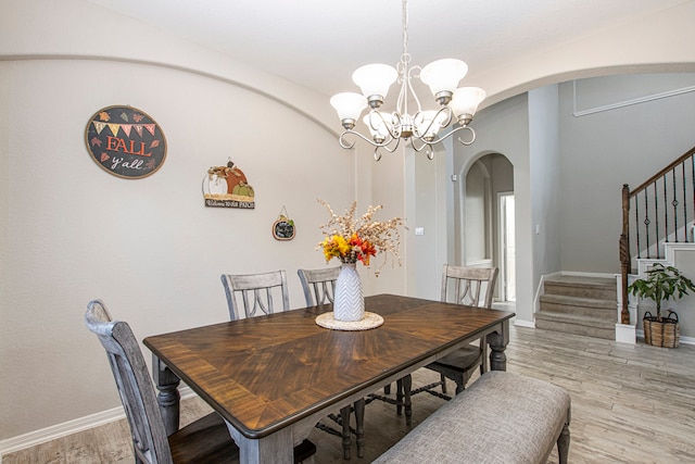 dining space featuring light hardwood / wood-style floors and an inviting chandelier