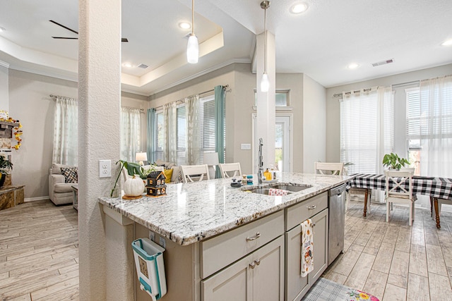 kitchen featuring light stone counters, light hardwood / wood-style floors, pendant lighting, and a wealth of natural light