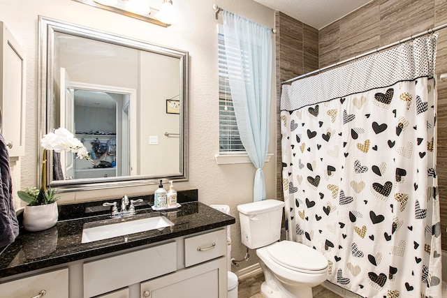 bathroom featuring toilet, a shower with curtain, vanity, and a textured ceiling