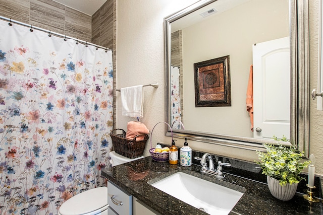 bathroom with walk in shower, vanity, and toilet