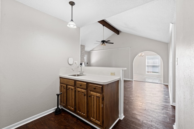 kitchen featuring lofted ceiling with beams, ceiling fan, dark hardwood / wood-style floors, sink, and kitchen peninsula