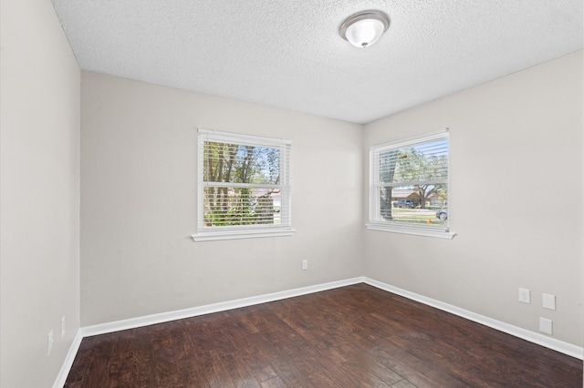 spare room featuring hardwood / wood-style flooring, a textured ceiling, and a healthy amount of sunlight