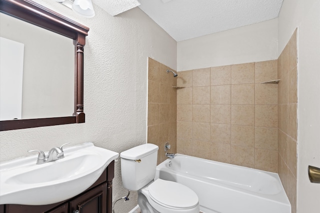 full bathroom featuring tiled shower / bath, vanity, toilet, and a textured ceiling