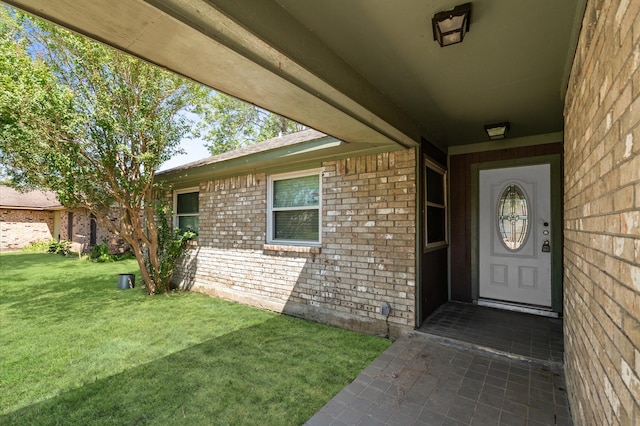 entrance to property with a lawn