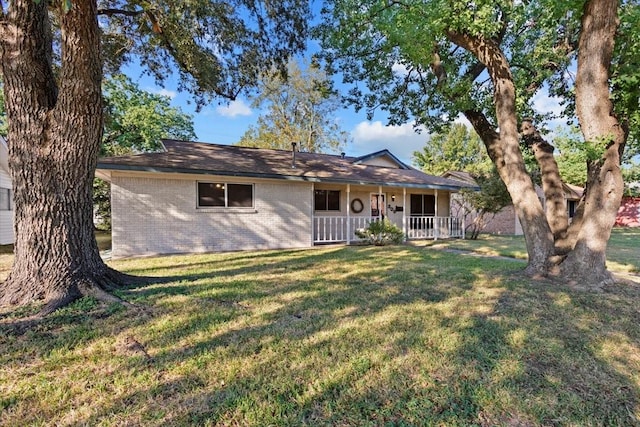 single story home featuring covered porch and a front yard