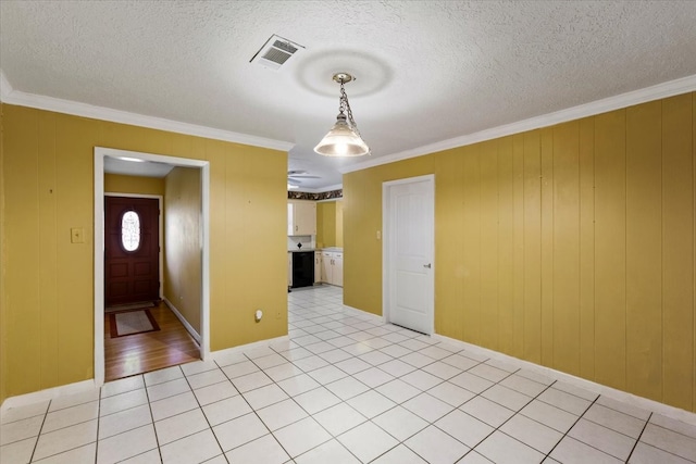 interior space featuring light tile patterned floors, a textured ceiling, and ornamental molding