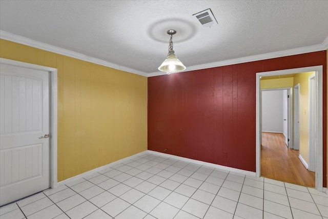 spare room featuring light tile patterned floors, a textured ceiling, and ornamental molding