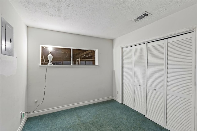 unfurnished bedroom featuring dark colored carpet, a textured ceiling, and a closet