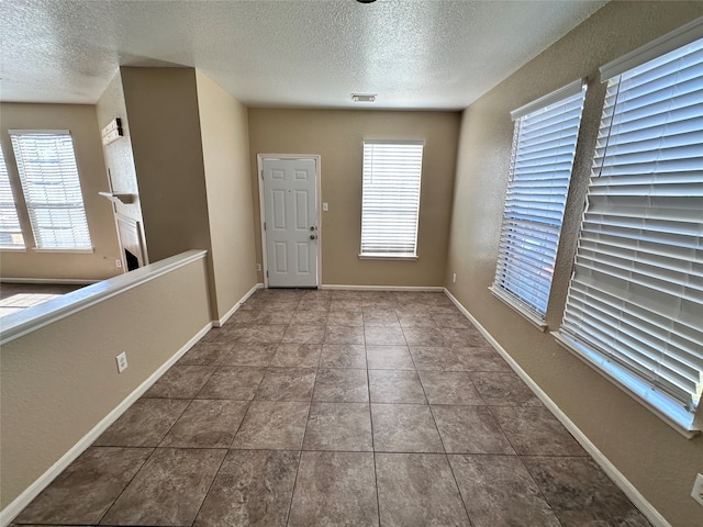 foyer entrance with tile patterned floors and a textured ceiling