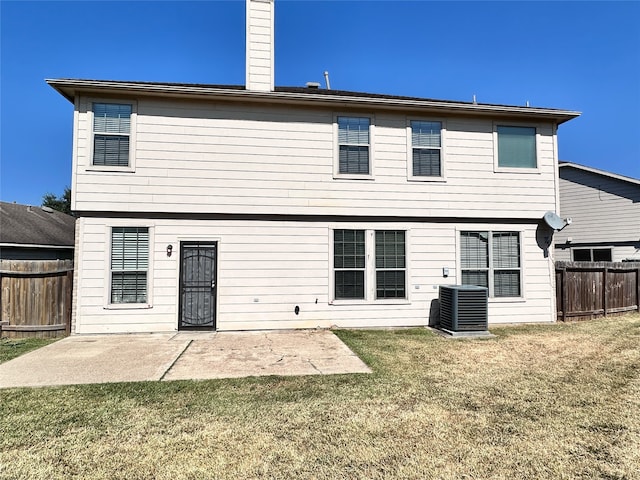 back of house with cooling unit, a lawn, and a patio