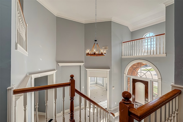 stairs with an inviting chandelier and crown molding