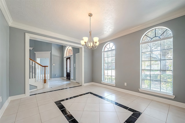 unfurnished dining area with a wealth of natural light, a textured ceiling, light tile patterned floors, and a notable chandelier