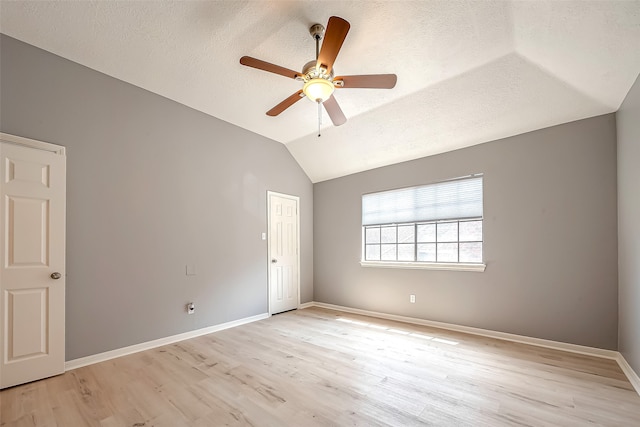 unfurnished room with ceiling fan, a textured ceiling, light hardwood / wood-style flooring, and vaulted ceiling